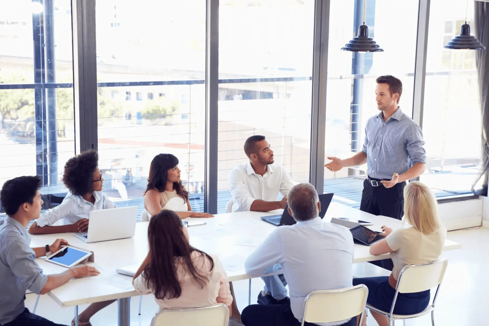 A team meeting in a bright office with a man presenting ideas.